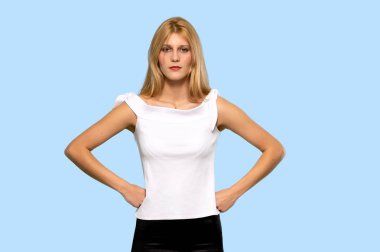 Sarışın genç kadın şaşırttı ve izole mavi arka plan üzerinde bir ileti gönderme