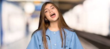 Bağırmanın bir hastanede geniş açık ağız ile ön genç hemşire