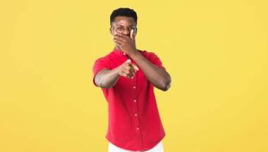 Birisi parmak ile işaret ve çok ağız Sarı zemin üzerine kapsayan süre gülüyor genç Afro-Amerikan adam