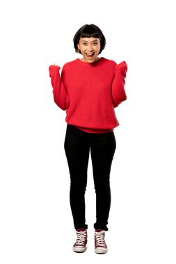 Kırmızı kazaklı bir zafer kazanan pozisyonda izole beyaz arka plan üzerinde kutluyor kısa saçlı kızla tam uzunlukta bir kadeh