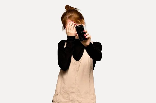 Jovem Ruiva Chateada Com Telefone Quebrado Sobre Fundo Cinza — Fotografia de Stock