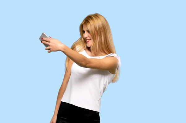 Young Blonde Woman Troubled Holding Broken Smartphone Isolated Blue Background — Stock Photo, Image