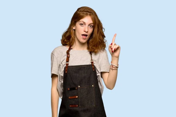 Young Redhead Woman Apron Showing Lifting Finger Sign Best Blue — Stock Photo, Image