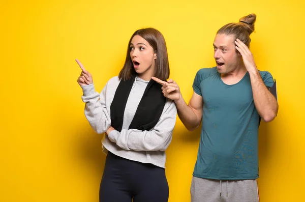 Grupo Atletas Sobre Fondo Amarillo Apuntando Con Dedo Hacia Lado —  Fotos de Stock