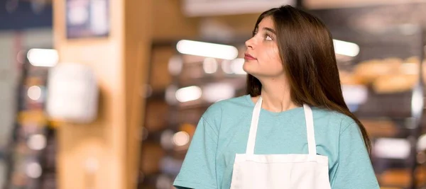 Meisje Met Schort Opzoeken Met Ernstige Gezicht Een Bakkerij — Stockfoto