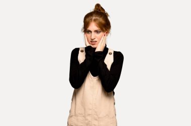 Gri arka plan üzerinde diş ağrısı ile genç Kızıl saçlı kadın