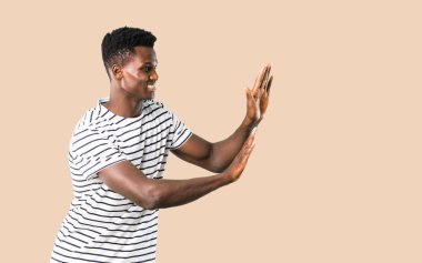 Çizgili gömlekli bir şey bastırıyor karanlık tenli adam izole