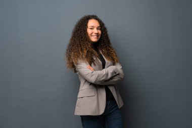 Genç kız üzerinde çarpı işareti silah ile mavi duvar ve ileriye dönük