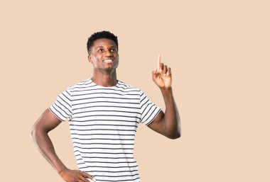 Koyu tenli adam ayakta ve bir IDE düşünme çizgili gömlek ile