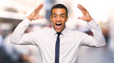 Sürpriz ve şehrin şok yüz ifadesi ile genç afro Amerikalı iş adamı