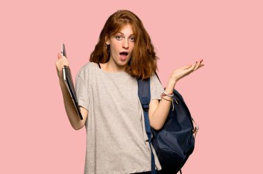 Genç redhead öğrenci grubu, sürpriz ve pembe bir arka plan üzerinde şok yüz ifadesi