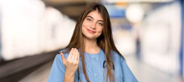 Genç hemşire el ile gelmek için davet. Mutlu bir hastanede geldi