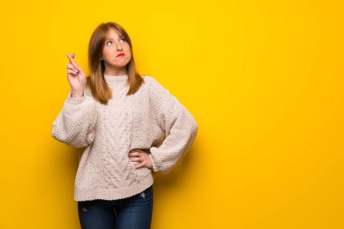 En iyi dilek ve geçiş parmaklarıyla sarı duvarın üzerinden Kızıl saçlı kadın