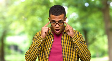 Genç afro Amerikalı adam gözlüklü ve sürpriz bir parkta