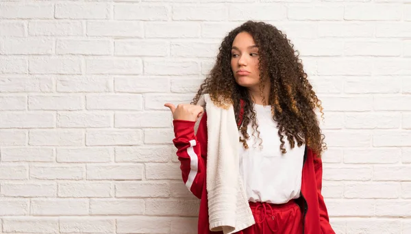 Adolescente Chica Deportiva Con Pelo Rizado Infeliz Apuntando Lado — Foto de Stock