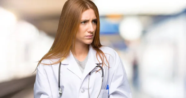 Redhead doctor woman feeling upset in the hospital