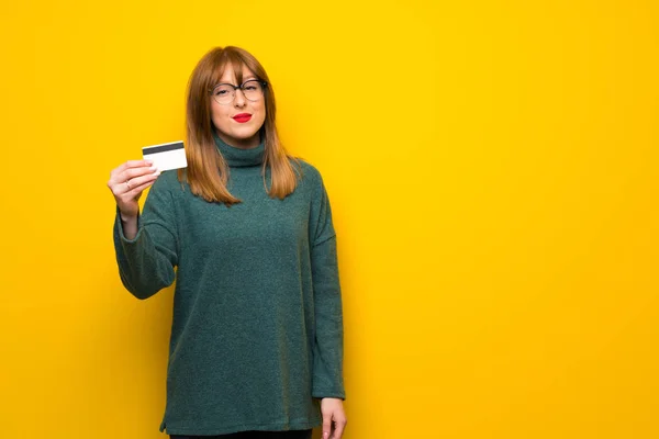 Vrouw Met Bril Gele Muur Houden Van Een Credit Card — Stockfoto