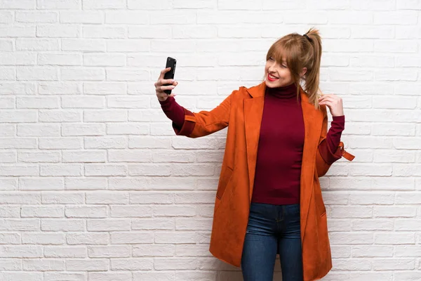 Γυναίκα Παλτό Πάνω Από Λευκό Τοίχο Κάνοντας Μια Selfie — Φωτογραφία Αρχείου