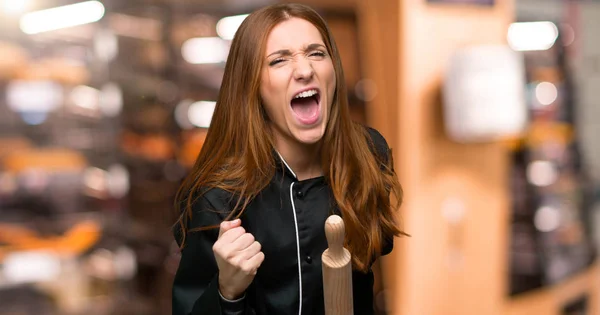 Young redhead chef woman frustrated by a bad situation in the bakery