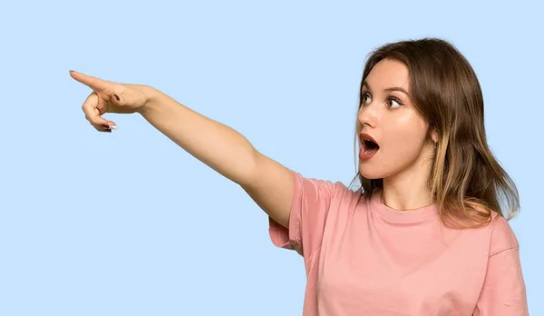 Menina Adolescente Com Suéter Rosa Apontando Para Longe Fundo Azul — Fotografia de Stock