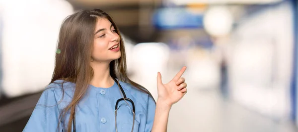 Jonge Verpleegster Wijzende Vinger Naar Kant Zijligging Een Ziekenhuis — Stockfoto