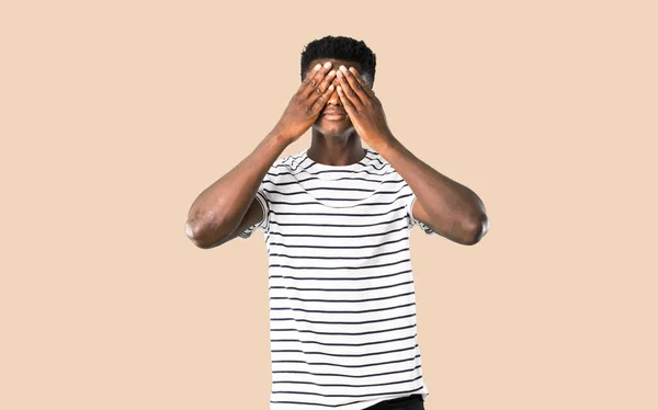 Hombre de piel oscura con camisa a rayas que cubre los ojos con las manos. Hacer n — Foto de Stock