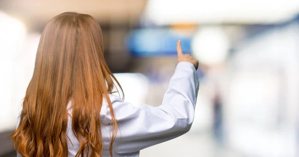 Mujer Doctora Pelirroja Señalando Hacia Atrás Con Dedo Índice Hospital —  Fotos de Stock