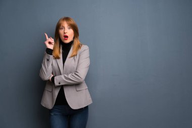 Kızıl saçlı iş kadın parmağı yukarıyı bir fikir düşünüyorum