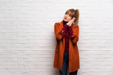 Kadın kat üzerinde beyaz tuğla duvar yapım uyku jest dorable ifade ile