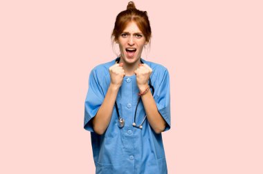 Pembe bir arka plan üzerinde kötü bir durum tarafından hayal kırıklığına uğramış genç redhead hemşire