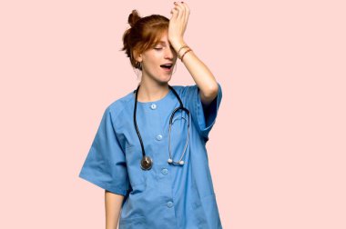 Genç redhead hemşire bir şeyin farkına vardım ve pembe arka plan üzerinde çözüm isteyen vardır