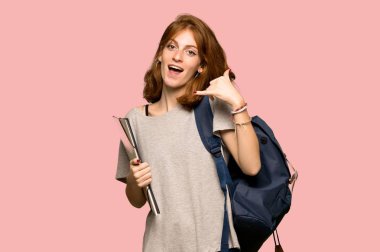 Genç redhead öğrenci telefon jest yapma. Bana pembe arka plan üzerinde arka işareti de