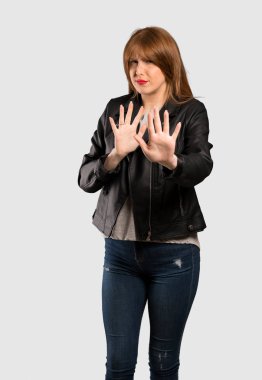 Gergin ve korkmuş elinde cepheye izole gri arka plan üzerinde uzanan genç Kızıl saçlı kadın