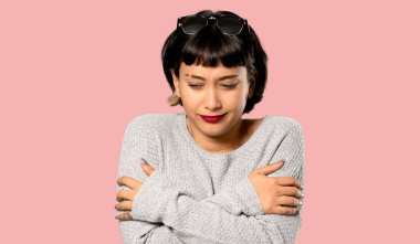 İzole pembe arka plan buz gibi kısa saçlı genç kadın