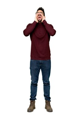 Bağırarak ve izole beyaz arka planda bir şey ilan gözlüklü yakışıklı adam tam uzunlukta atış