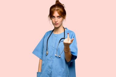 Genç redhead Hemşire yapım boynuz jest pembe bir arka plan üzerinde