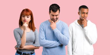 Grup üç arkadaşıyla birlikte ayakta ve aşağı bakıyor