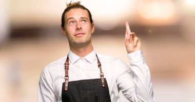 Bir berber dükkanı en iyi dilek ve geçiş parmak ile apronda Kuaför adam