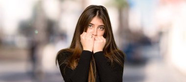 Biraz gergin ve korkmuş için ağzı açık havada ellerini koyarak güzel kız