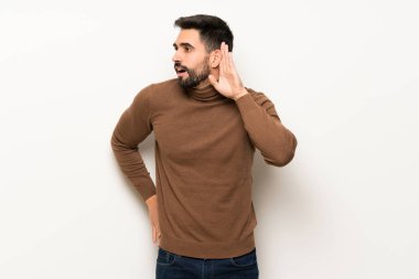 Beyaz duvar için bir şey kulak el koyarak dinleme yakışıklı adam