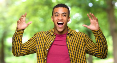 Sürpriz ve şok yüz ifadesi bir parkta genç afro Amerikalı adam