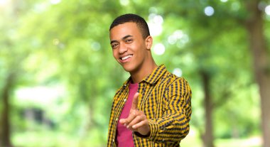 Gösterilen ve bir parkta parmak kaldırma genç afro Amerikalı adam