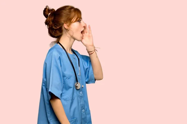 Jovem Enfermeira Ruiva Gritando Com Boca Bem Aberta Para Lado — Fotografia de Stock