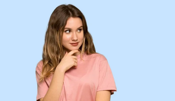 Menina Adolescente Com Suéter Rosa Olhando Para Frente Fundo Azul — Fotografia de Stock