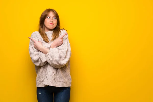 疑問を持つ根を指している黄色の壁を越えて赤毛の女性 — ストック写真