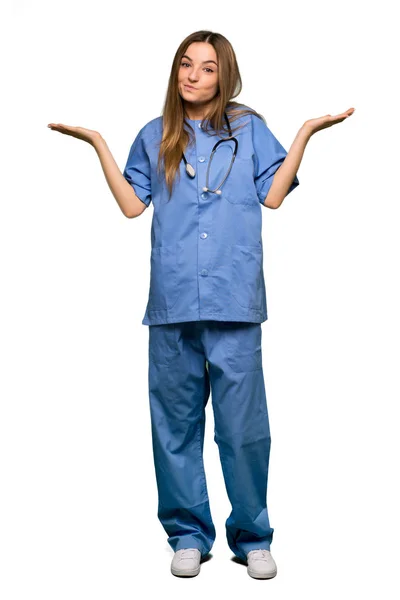 Ganzkörperjunge Krankenschwester Mit Zweifeln Während Sie Vor Isoliertem Hintergrund Hände — Stockfoto
