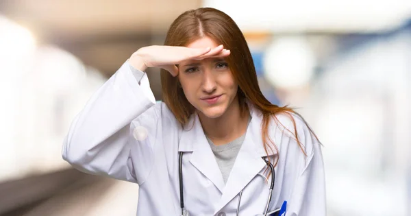 Κοκκινομάλλης Γυναίκα Γιατρός Κοιτάζοντας Πολύ Μακριά Χέρι Φανεί Κάτι Στο — Φωτογραφία Αρχείου