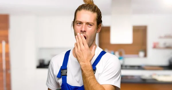 あくびをし 家で手で大きく開いて口を覆っている職人 — ストック写真