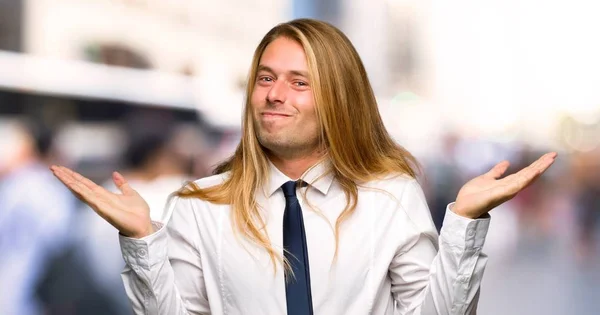 Blonder Geschäftsmann Mit Langen Haaren Zweifelt Während Draußen Hände Und — Stockfoto