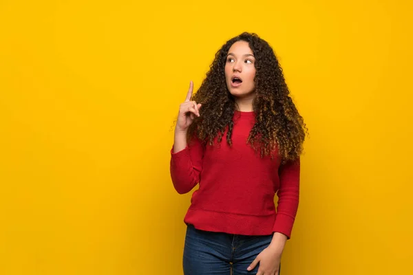 Chica Adolescente Con Suéter Rojo Sobre Pared Amarilla Con Expresión —  Fotos de Stock